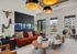 Modern apartment lounge featuring a vibrant red sofa, sleek wooden coffee tables, and a large fish tank accentuated by stylish lighting.
