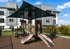 Modern apartment complex with a vibrant playground featuring a covered slide and climbing structure, perfect for family-friendly living.