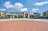 Modern apartment complex with stylish design, abundant windows, and lush landscaping under a bright blue sky.