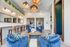 Chic communal living space featuring plush blue seating, modern lighting, and inviting decor for a relaxed atmosphere.