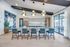 Sleek modern kitchen with a large island, elegant pendant lights, and chic blue chairs, perfect for stylish gatherings and culinary adventures.