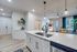 Modern open kitchen with sleek countertops, stylish pendant lighting, and inviting living area filled with natural light.
