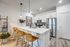 Modern kitchen with sleek white cabinetry, stainless steel appliances, and a chic breakfast bar with stylish leather stools.