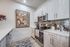 Bright and modern kitchen with sleek stainless steel appliances, stylish cabinetry, and elegant wall art enhancing the contemporary vibe.