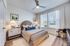 Inviting bedroom featuring stylish decor, elegant lighting, and ample natural light through large windows, creating a serene and cozy retreat.