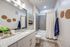 Elegant bathroom featuring modern grey tiles, stylish granite countertop with decorative accents, and soothing wall art for a tranquil vibe.