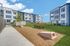 Charming apartment exterior with modern design, lush green spaces, and inviting bench seating for relaxation.