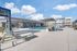 Luxurious modern apartment complex featuring a sparkling pool, stylish lounge chairs, and contemporary architecture under a bright blue sky.