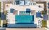 Aerial view of a luxurious outdoor swimming pool surrounded by stylish lounge chairs, shaded areas, and vibrant green landscaping.