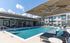 Luxurious outdoor pool area with stylish loungers and spacious umbrellas at a modern apartment complex.