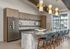 Modern kitchen with elegant pendant lighting, a large island with stylish seating, and sleek cabinetry perfect for entertaining.
