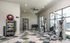 Modern fitness room with state-of-the-art exercise equipment, featuring kettlebells, medicine balls, and large windows for natural light.