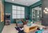 Chic recreation room with retro arcade machines, plush seating, stylish d&eacute;cor, and vibrant art on teal walls.