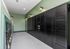 Modern mailroom with sleek black locker units and elegant wall lighting, featuring green accents.