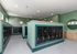 Modern mailroom with sleek black mailboxes and elegant green walls, enhanced by contemporary lighting and minimalist design.