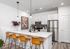 Modern kitchen with sleek stainless steel appliances, elegant pendant lighting, and a stylish breakfast bar with leather seating.