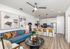 Modern open-concept living space with stylish decor, featuring a cozy blue sofa, sleek kitchen island with bar stools, and elegant marble coffee table.