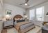 Inviting bedroom with elegant decor, featuring a plush bed, stylish lamps, and large windows offering natural light.