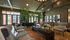 Elegant communal lounge featuring modern decor, comfortable seating, lush indoor plants, and expansive windows with city views.