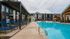 Luxurious apartment community with a pristine outdoor pool, relaxing lounge area, and modern architecture.