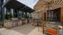 Chic outdoor entertainment area with modern grills, stylish patio seating, and striped umbrellas for shaded comfort.