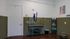 Modern pet grooming room with stylish green tile accents, featuring a grooming table and tasteful decor.