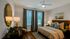 Charming bedroom featuring cozy lighting, elegant decor, and large windows with a relaxing view, perfect for a restful retreat.