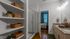 Bright, modern bathroom with elegant granite countertops, sleek shower enclosure, and built-in shelves with wicker baskets for storage.