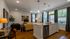 Elegant open-concept living space featuring modern kitchen with granite countertops and stylish seating area with cozy couches.