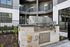 Modern outdoor barbecue area with sleek grill in a stylish apartment courtyard, perfect for social gatherings.
