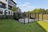 Charming apartment exterior with modern design, fenced courtyard, and lush green surroundings.