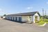 Charming outdoor view of a modern garage facility with multiple units, surrounded by well-maintained greenery and clear blue skies.