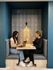 Cozy modern alcove with two people engaged in conversation, featuring stylish seating and ambient lighting.