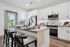 Modern kitchen with sleek white cabinets, stainless steel appliances, and a stylish breakfast bar with seating for three.