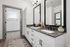 Elegant bathroom with dual sinks, modern fixtures, and sleek cabinetry connected to a bright walk-in closet.