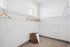 Spacious and bright walk-in closet with modern shelving and ample storage space, perfect for stylish organization.