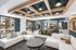 Modern and inviting communal lounge with plush seating, stylish lighting, and expansive windows offering views of an outdoor pool area.