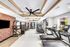 Modern fitness center with state-of-the-art exercise equipment, stylish brick accent wall, and large windows for natural light.