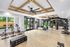 Modern fitness center with sleek exercise equipment, spin bikes, and a vibrant outdoor view, offering a dynamic workout environment.