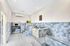 Chic, modern utility room with stylish geometric blue tiles, stainless steel work area, and sleek fixtures. Bright and inviting space with ample natural light.
