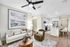 Modern open-concept living area featuring a chic living room with stylish furniture, contemporary art, and a sleek kitchen with a breakfast bar.