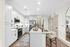 Modern kitchen with sleek white cabinetry, stainless steel appliances, and a spacious island perfect for dining and gatherings.
