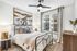 Elegant bedroom featuring modern artwork, cozy decor, and large window for natural light.