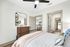 Elegant bedroom featuring modern decor, cozy bedding, and an inviting view into a stylish kitchen.