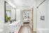 Chic modern bathroom with a spacious vanity, stylish decor, and a view into a sunlit bedroom, offering a serene and inviting ambiance.