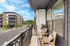 Charming balcony view with cozy seating and scenic landscape in modern apartment complex.