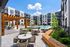 Modern apartment courtyard featuring a sparkling pool, stylish pergola, and elegant seating area surrounded by contemporary architecture.