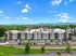 Modern apartment complex with scenic mountain backdrop, featuring well-maintained grounds and ample parking.