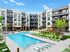 Modern apartment complex with a stunning outdoor pool, sun loungers, and lush greenery, offering a luxurious living experience.