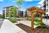 Modern apartment complex with beautiful landscaping and wooden pergola swings for relaxation.